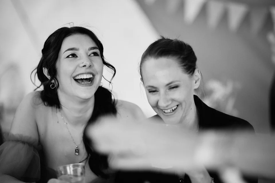 Wedding guests laughing together in black and white