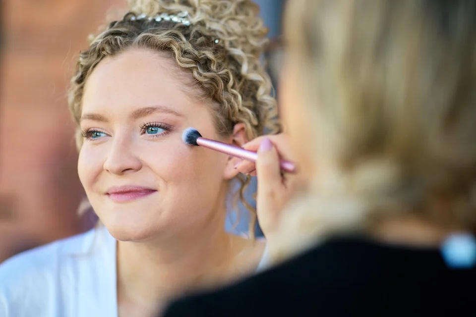The bride having her makeup finished