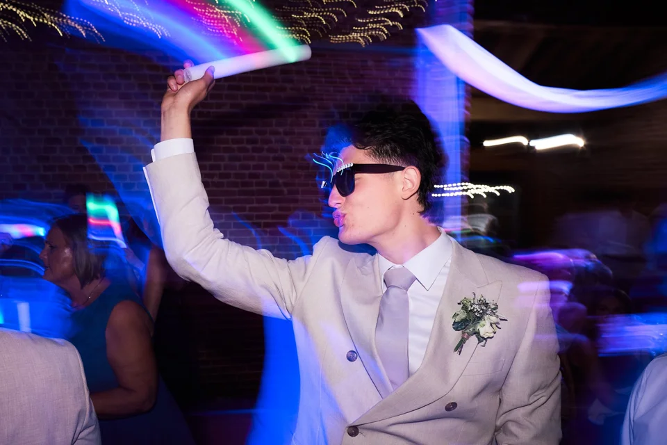 The groom celebrating with glowing party sticks