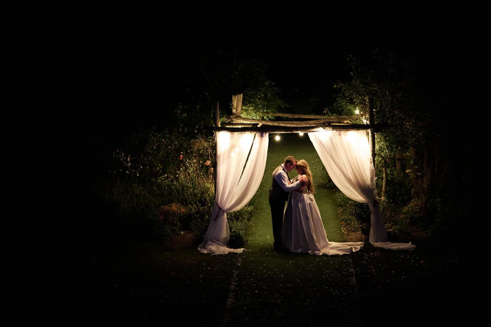 The couple framed by curtains and light after dark